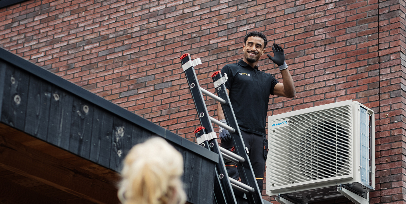 Warmtepomp buitenunit naast een Nederlandse woning